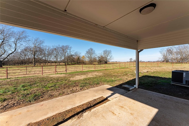 view of yard with a patio, a rural view, and central air condition unit