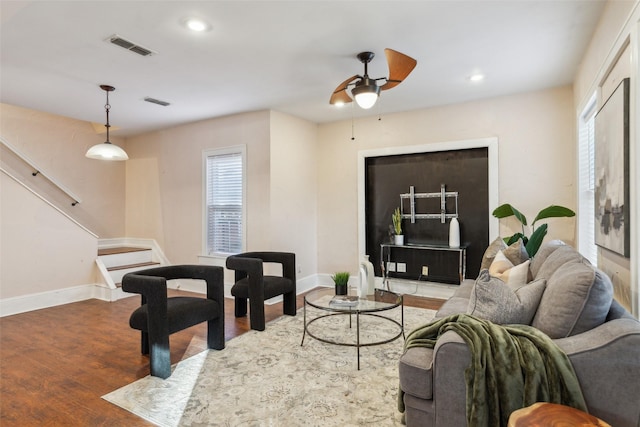 living room featuring wood-type flooring and ceiling fan