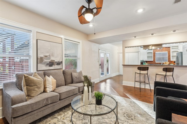 living room featuring ceiling fan, wood-type flooring, and french doors