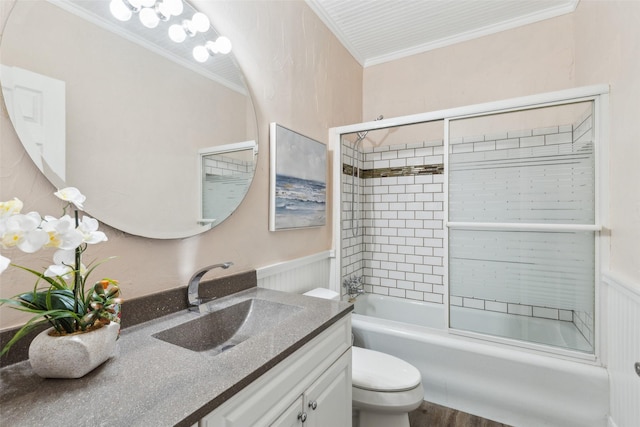 full bathroom featuring hardwood / wood-style floors, vanity, combined bath / shower with glass door, toilet, and ornamental molding