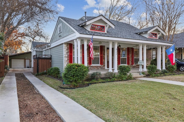 bungalow-style house featuring a front lawn, covered porch, an outdoor structure, and a garage