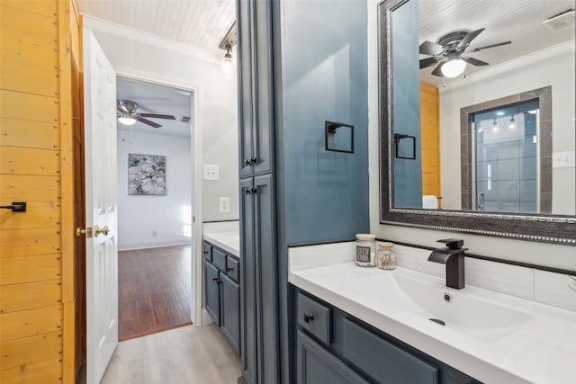 bathroom with vanity, crown molding, ceiling fan, and wood-type flooring