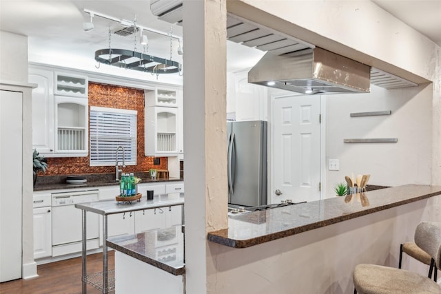 kitchen with white cabinetry, dark wood-type flooring, a kitchen breakfast bar, tasteful backsplash, and appliances with stainless steel finishes