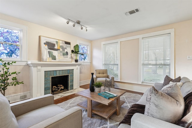 living room with a tile fireplace and light hardwood / wood-style floors