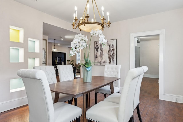 dining space featuring dark hardwood / wood-style flooring and a chandelier