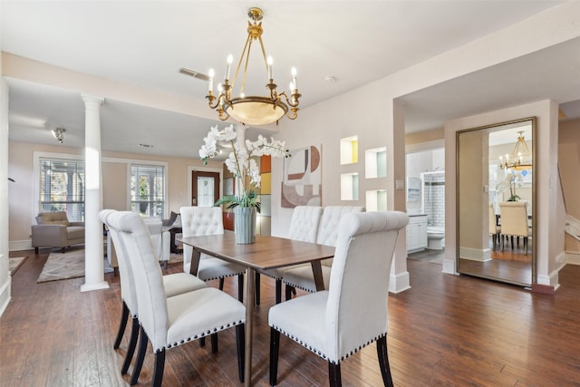 dining area featuring ornate columns, dark wood-type flooring, and a notable chandelier