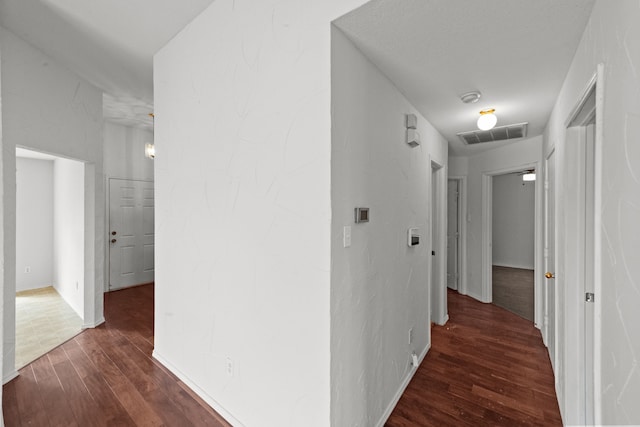 corridor with dark hardwood / wood-style flooring