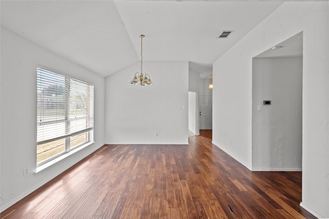 empty room with a chandelier, dark wood-type flooring, and lofted ceiling