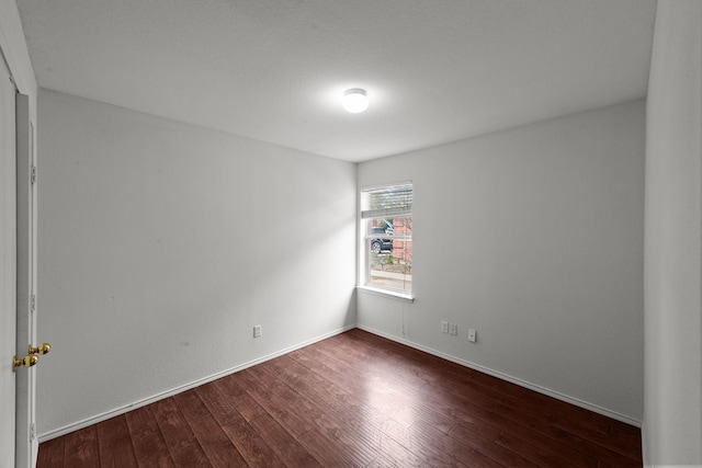 empty room with dark hardwood / wood-style flooring