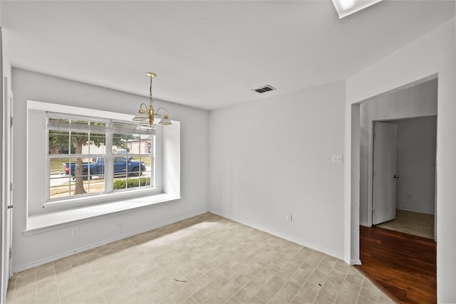 spare room featuring light hardwood / wood-style flooring and a notable chandelier