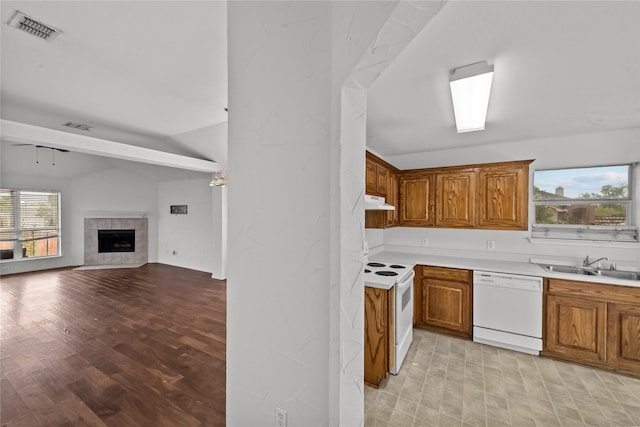 kitchen featuring white appliances, sink, a fireplace, light hardwood / wood-style floors, and lofted ceiling