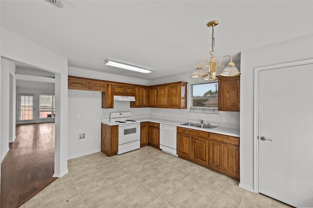 kitchen with plenty of natural light, decorative light fixtures, white appliances, and sink