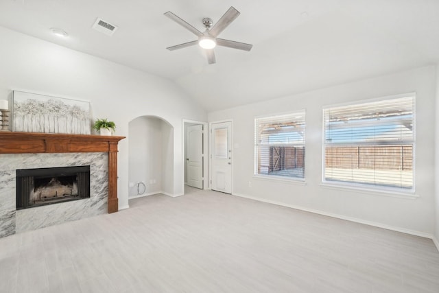 unfurnished living room with a fireplace, ceiling fan, and vaulted ceiling