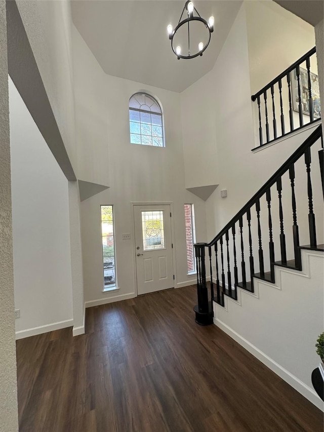 foyer entrance featuring dark hardwood / wood-style floors, a high ceiling, and a chandelier