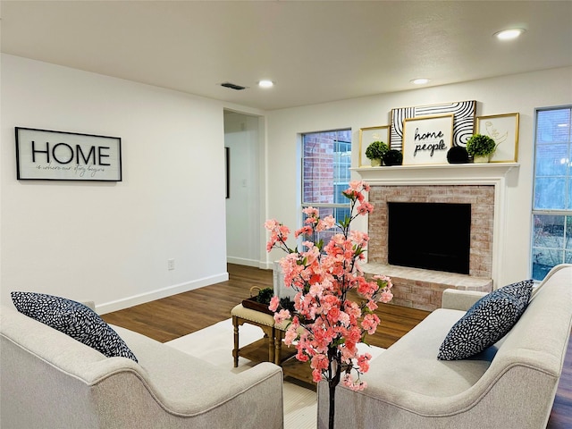 living room featuring hardwood / wood-style floors and a brick fireplace