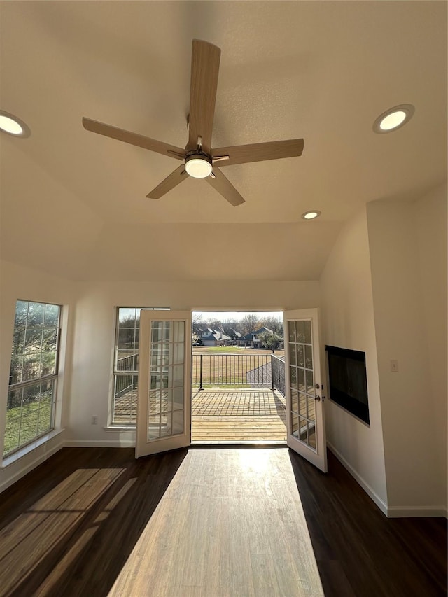 unfurnished living room featuring dark wood-type flooring, ceiling fan, and lofted ceiling