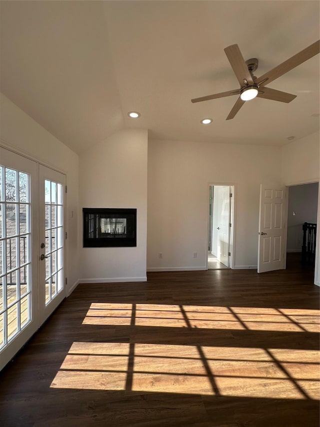 unfurnished living room with dark hardwood / wood-style floors, ceiling fan, french doors, and vaulted ceiling