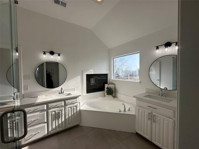 bathroom featuring tile patterned floors, a washtub, vanity, and lofted ceiling