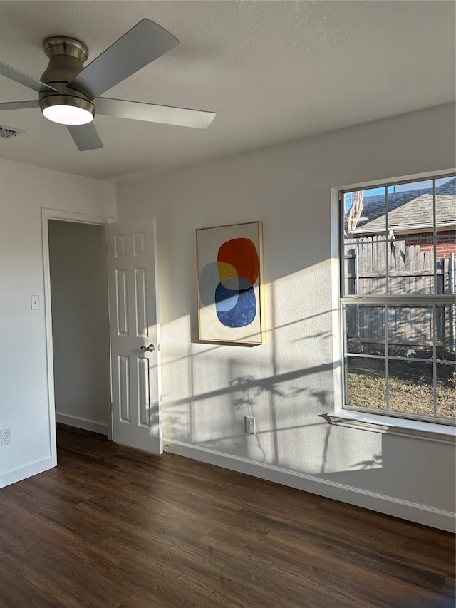 unfurnished room with ceiling fan and dark hardwood / wood-style floors