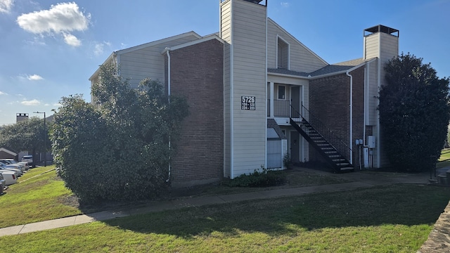 view of side of home with a yard