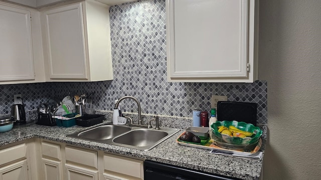 kitchen featuring backsplash, black dishwasher, white cabinets, and sink