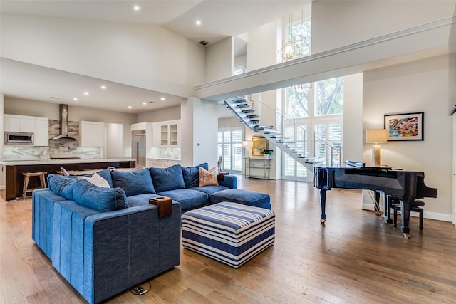 living room featuring high vaulted ceiling and light wood-type flooring