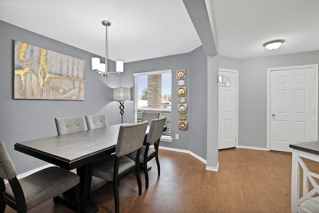 dining area with wood-type flooring and a chandelier