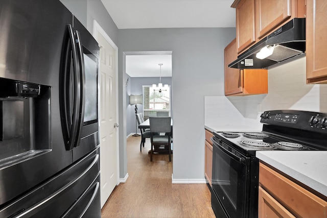 kitchen featuring decorative light fixtures, tasteful backsplash, refrigerator with ice dispenser, electric range, and light hardwood / wood-style flooring