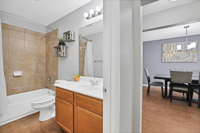 full bathroom featuring wood-type flooring, toilet, shower / bathtub combination with curtain, and vanity