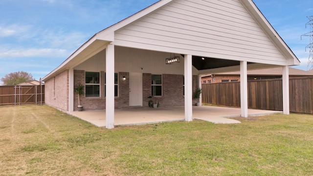 rear view of property featuring a lawn and a patio area