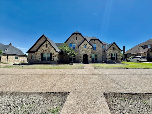 french country style house with a residential view, brick siding, and stone siding