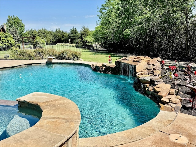 view of pool featuring a yard, a pool with connected hot tub, and fence