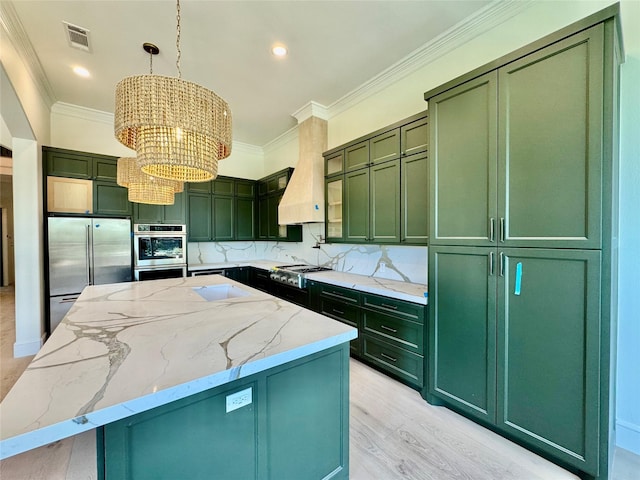 kitchen featuring tasteful backsplash, ornamental molding, appliances with stainless steel finishes, and green cabinets