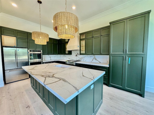 kitchen featuring green cabinetry, appliances with stainless steel finishes, ornamental molding, a notable chandelier, and hanging light fixtures