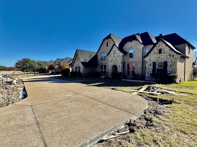 french country style house with stone siding