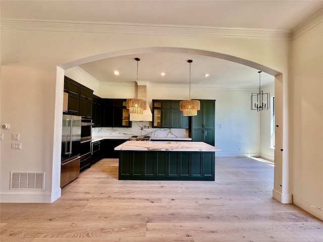 kitchen with custom exhaust hood, high end fridge, light wood-style flooring, a kitchen island, and visible vents
