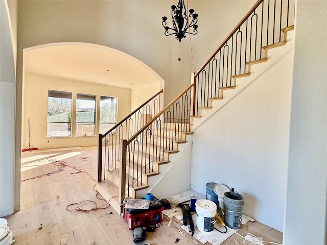 stairs with hardwood / wood-style flooring and an inviting chandelier