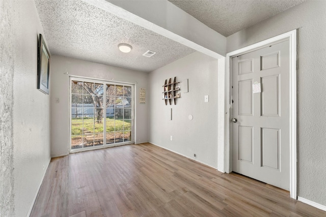 foyer featuring a textured ceiling and light hardwood / wood-style floors