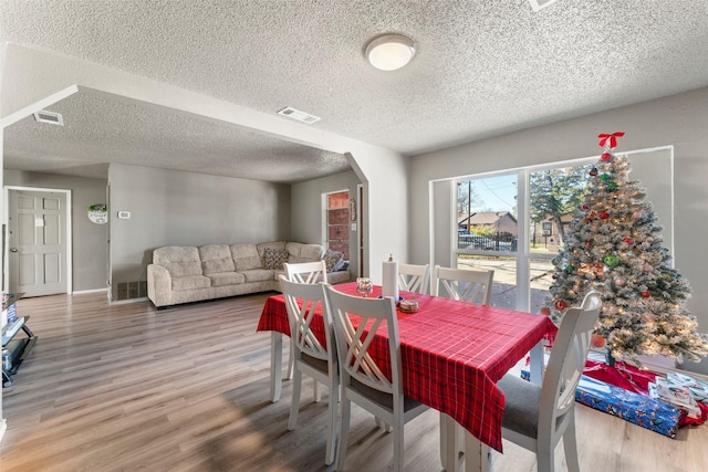 dining area featuring hardwood / wood-style floors and a textured ceiling