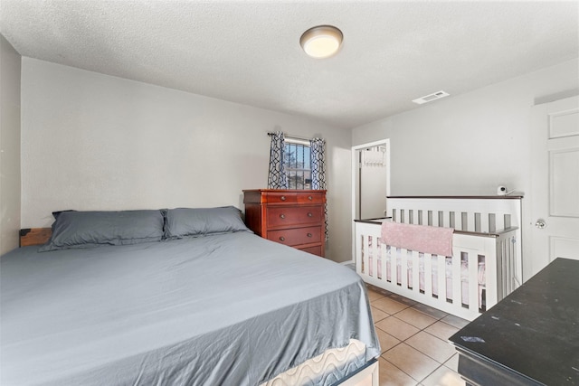 tiled bedroom with a textured ceiling