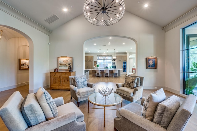 living room with a wealth of natural light, light hardwood / wood-style flooring, and high vaulted ceiling