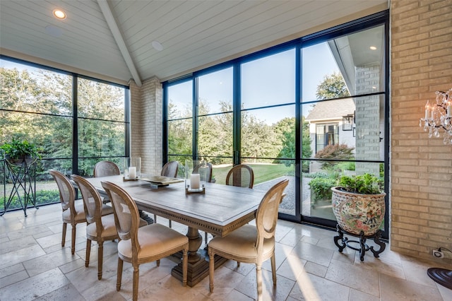 sunroom / solarium with vaulted ceiling with beams and a chandelier