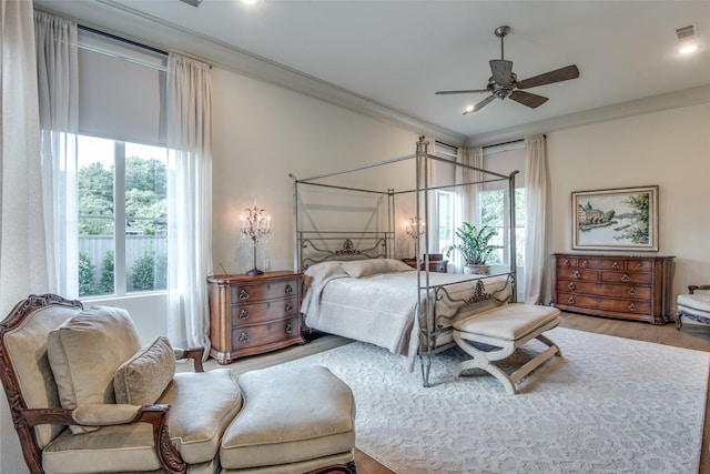 bedroom with hardwood / wood-style flooring, ceiling fan, and ornamental molding