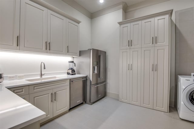 laundry room featuring light tile patterned flooring, sink, and washer / clothes dryer