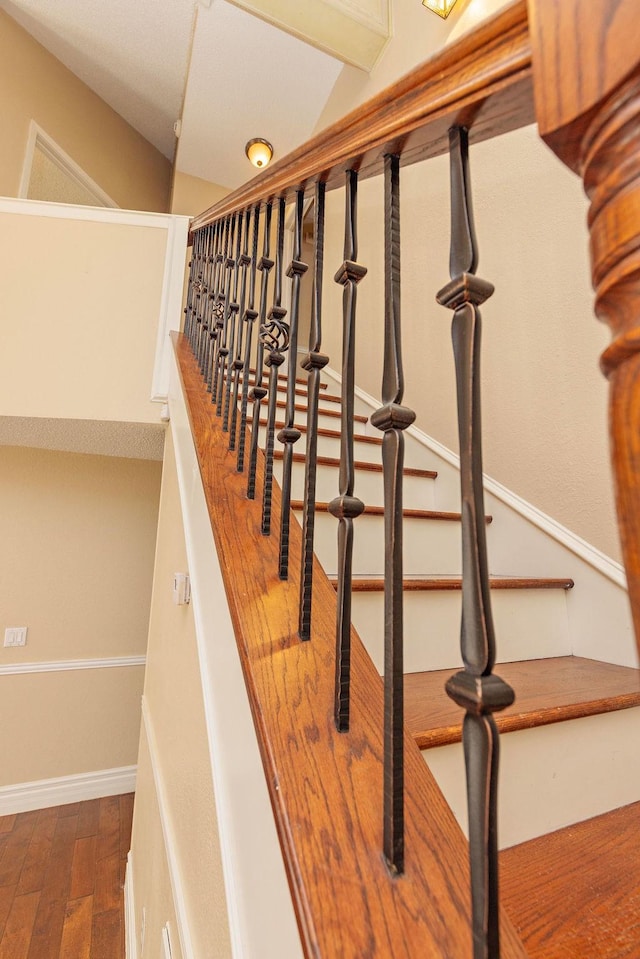 staircase featuring hardwood / wood-style floors and vaulted ceiling