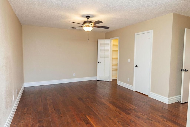 empty room with dark wood-type flooring, a textured ceiling, and ceiling fan