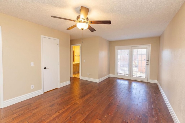 spare room with ceiling fan, a textured ceiling, and dark hardwood / wood-style flooring