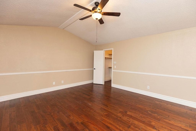 empty room with ceiling fan, a textured ceiling, dark hardwood / wood-style floors, and vaulted ceiling