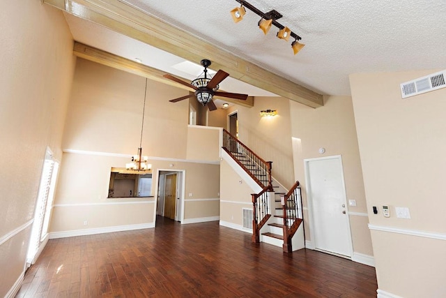 unfurnished living room with ceiling fan with notable chandelier, a textured ceiling, beamed ceiling, dark hardwood / wood-style floors, and high vaulted ceiling