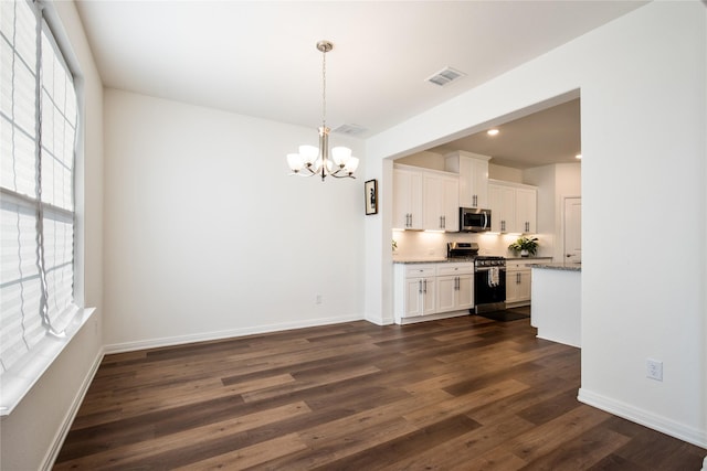 kitchen with white cabinetry, dark hardwood / wood-style flooring, light stone countertops, and appliances with stainless steel finishes